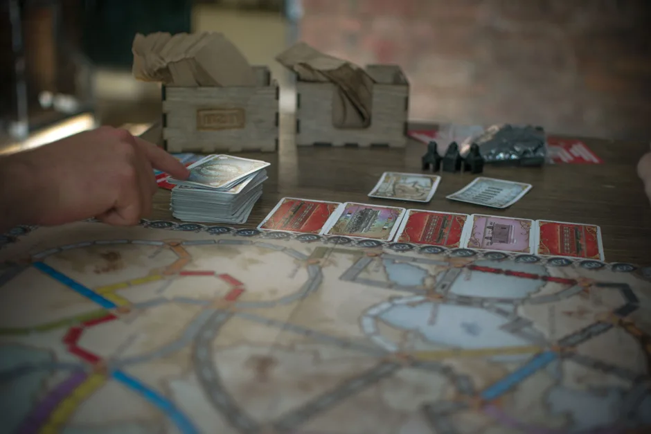 Plateau des Aventuriers du Rail avec trains colorés, cartes wagon et objectifs secrets sur une table.